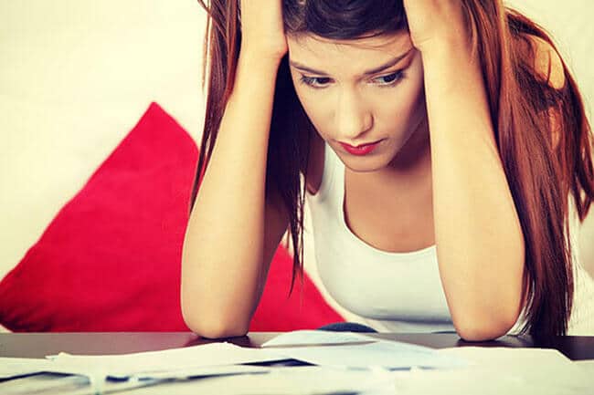 woman paying bills wonders about eating disorder causes