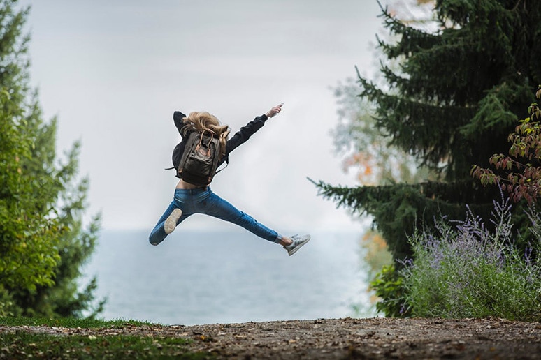 stock photo of a woman jumping in the woods