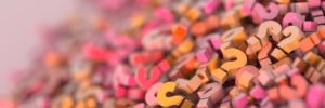 A pile of 3D question marks in pink, yellow, and orange colors.