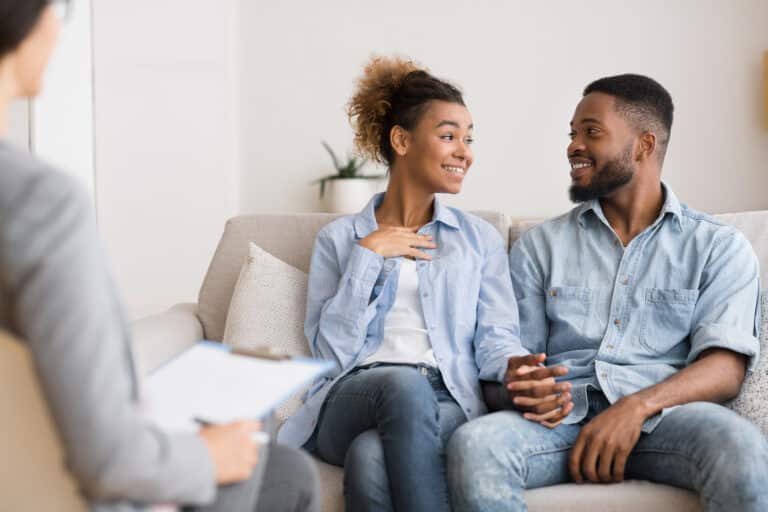 Cheerful Afro Couple Sharing News With Marital Therapist After Reconciliation